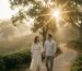 Couple walking through misty tea garden at golden hour